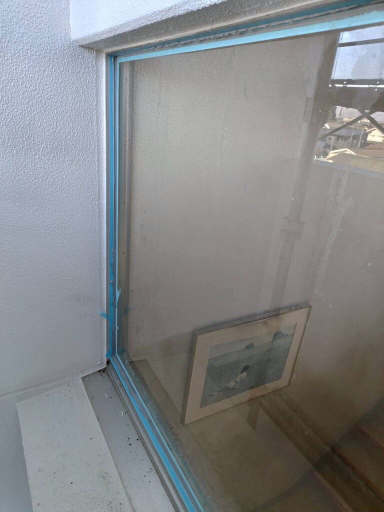 コーキングを打つ時はマスキングテープを貼ります。こうすることでコーキングの仕上がりが美しく直線的なものとなり、また汚れ防止やコーキング材の機能を最大限に活かすことが出来ます。仕上がりの精度を左右する、大切な工程です。